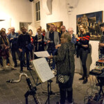 Een vrouw houd bladmuziek vast tussen verschillende instrumenten